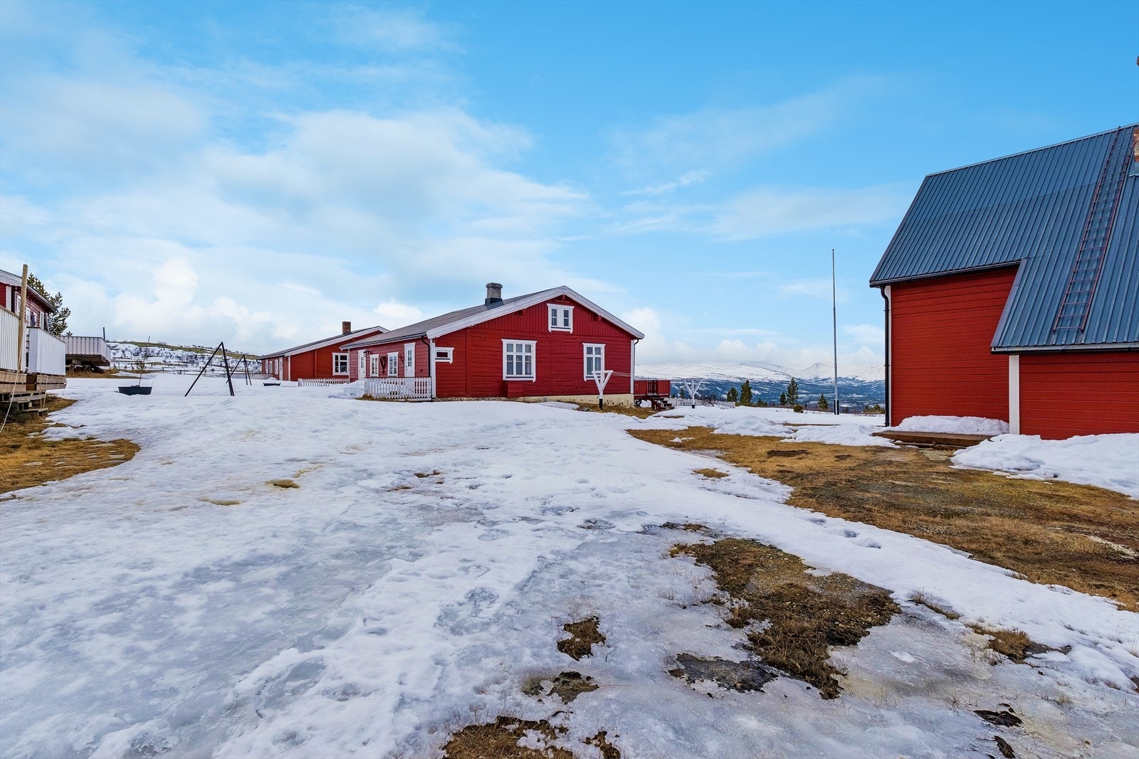 Felles, gruset innkjørsel og parkeringsplass for beboerne på tunet. Galleribilde