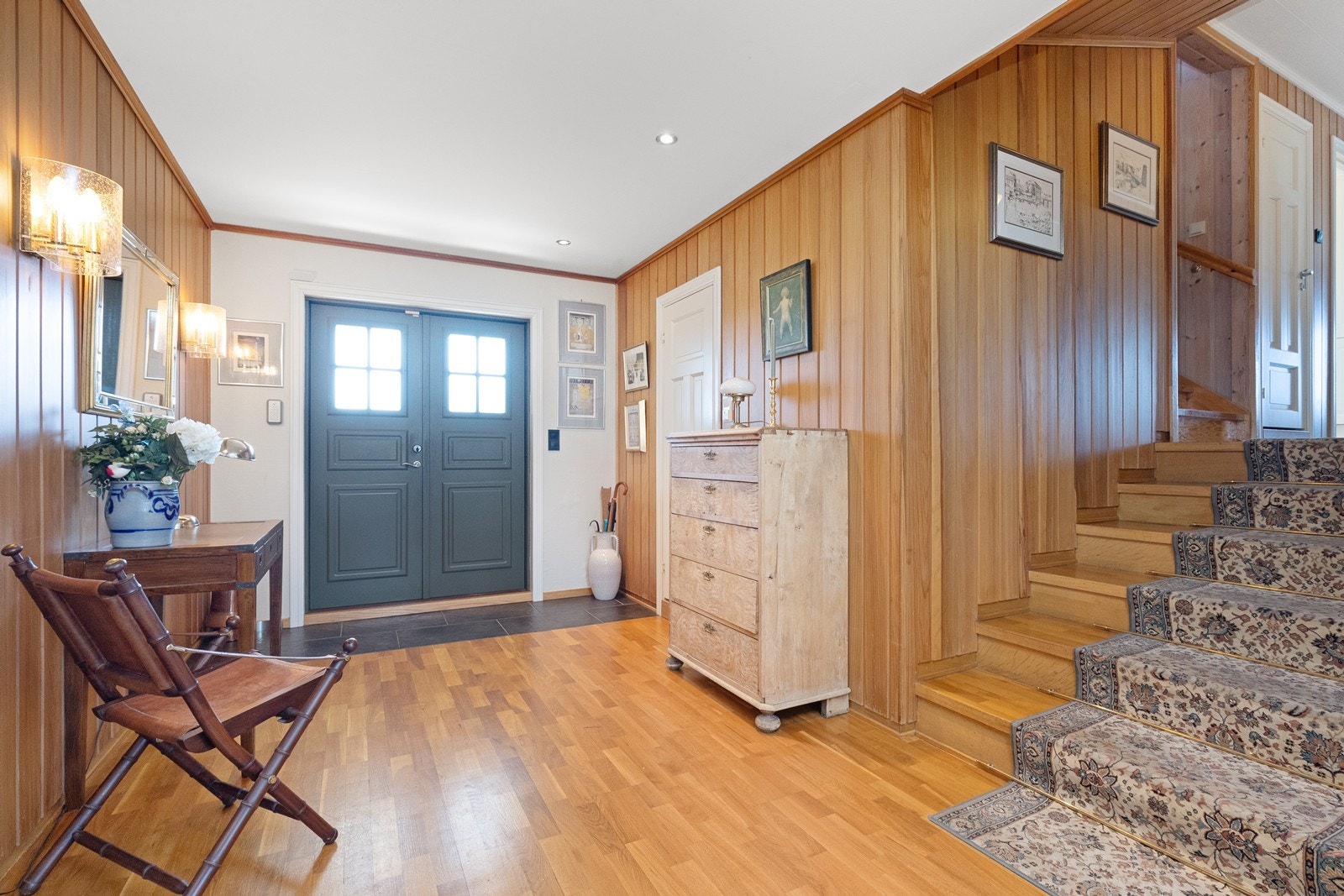 En tofløyet ytterdør fra 2009 ønsker velkommen inn i en romslig hall med fliser/parkett og varmekabler. Galleribilde