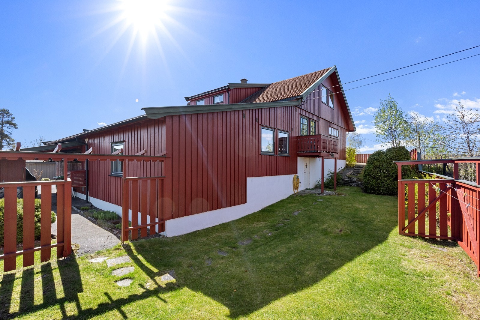 Tomten er opparbeidet med plenarealer, beplantning og natursteinsmurer. Galleribilde
