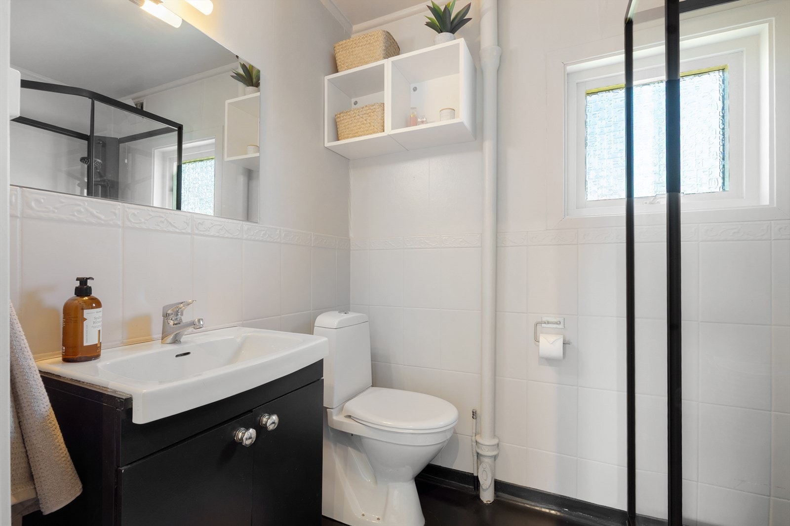 Badet i første etasje har vinylbelegg på gulv, flis og tapet på veggene, og er utstyrt med dusjkabinett. Galleribilde