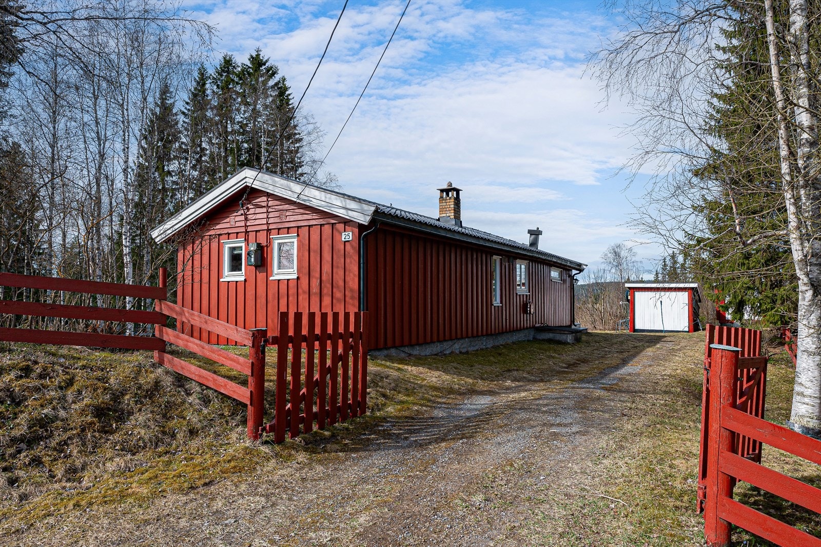 Koselig innkjørsel med port, tomten er dels inngjerdet. Galleribilde