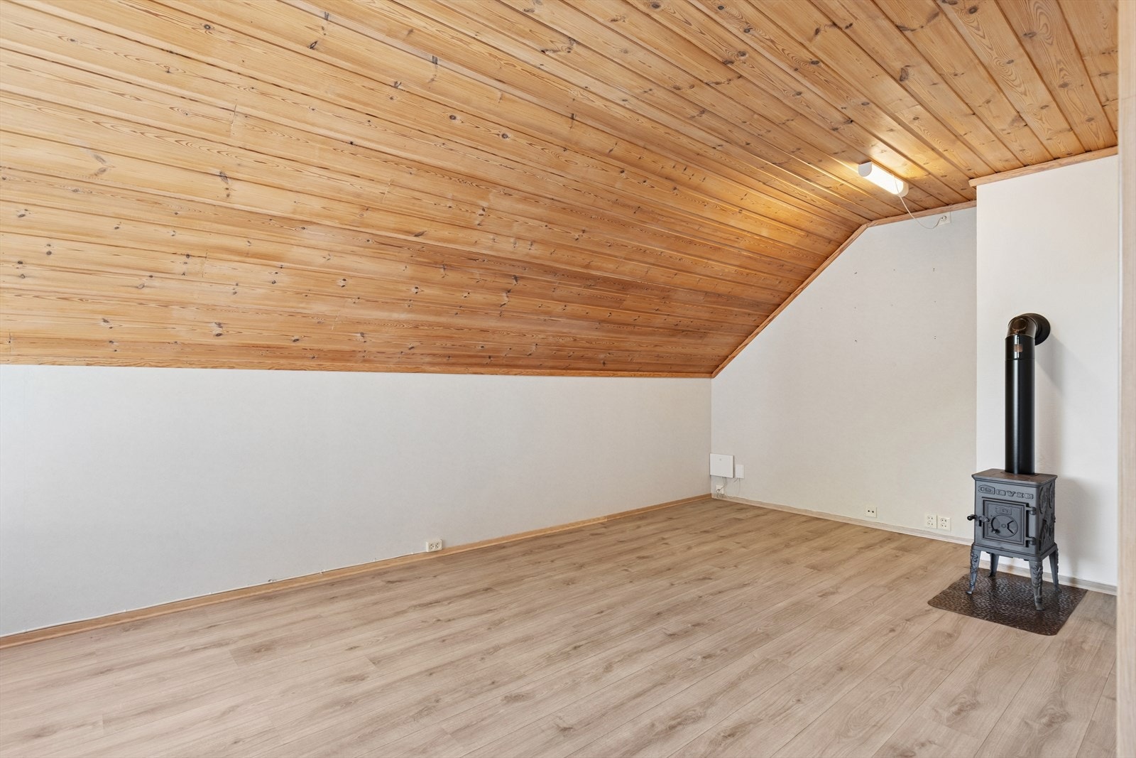 Stuen er romslig med gode soner for innredning. Her er det også en peis som bidrar til økt komfort og effektiv oppvarming. Galleribilde