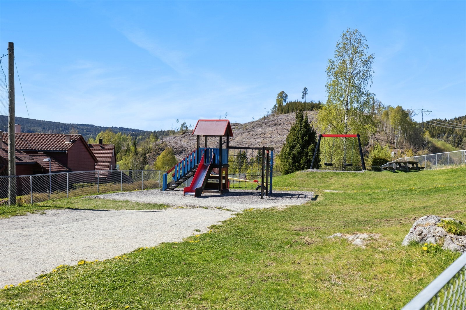 Fellesarealene er pent opparbeidet med grusbelagt gårdsplass, gressplen og lekeapparater. Galleribilde