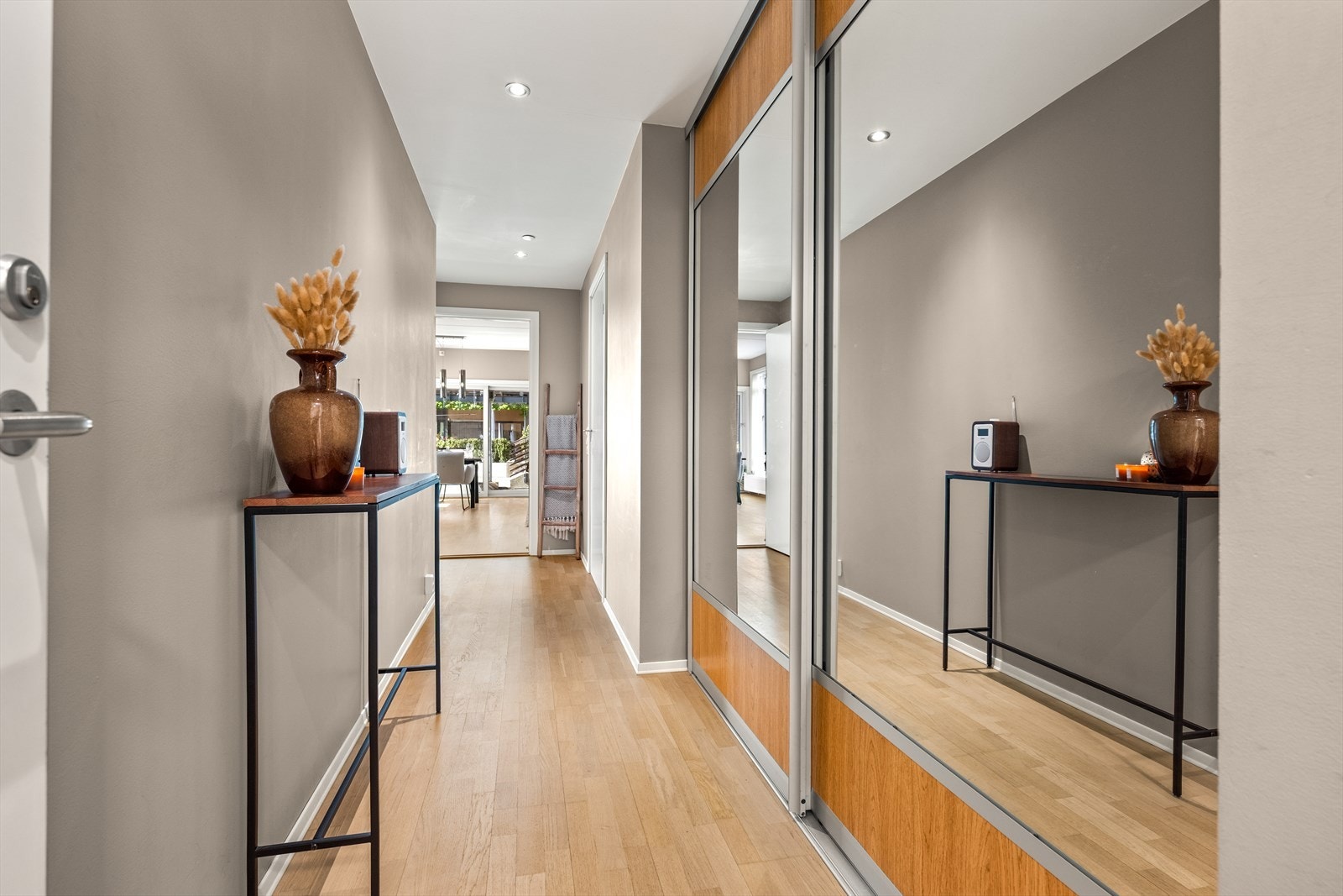 Entréen har en praktisk skyvedørsgarderobe med speilfronter. Parkett på gulv og malte flater på veggene. Galleribilde