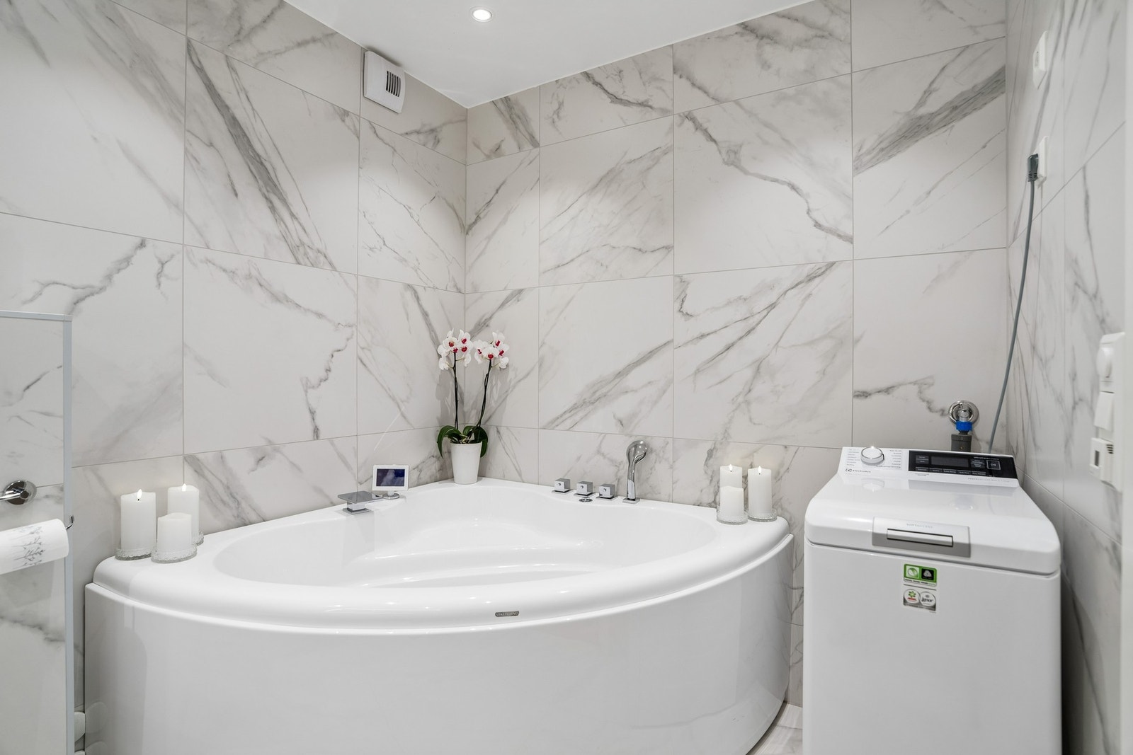 Badet er innredet med vegghengt toalett, boblebadekar og stilrene detaljer som gir et helhetlig uttrykk. Galleribilde