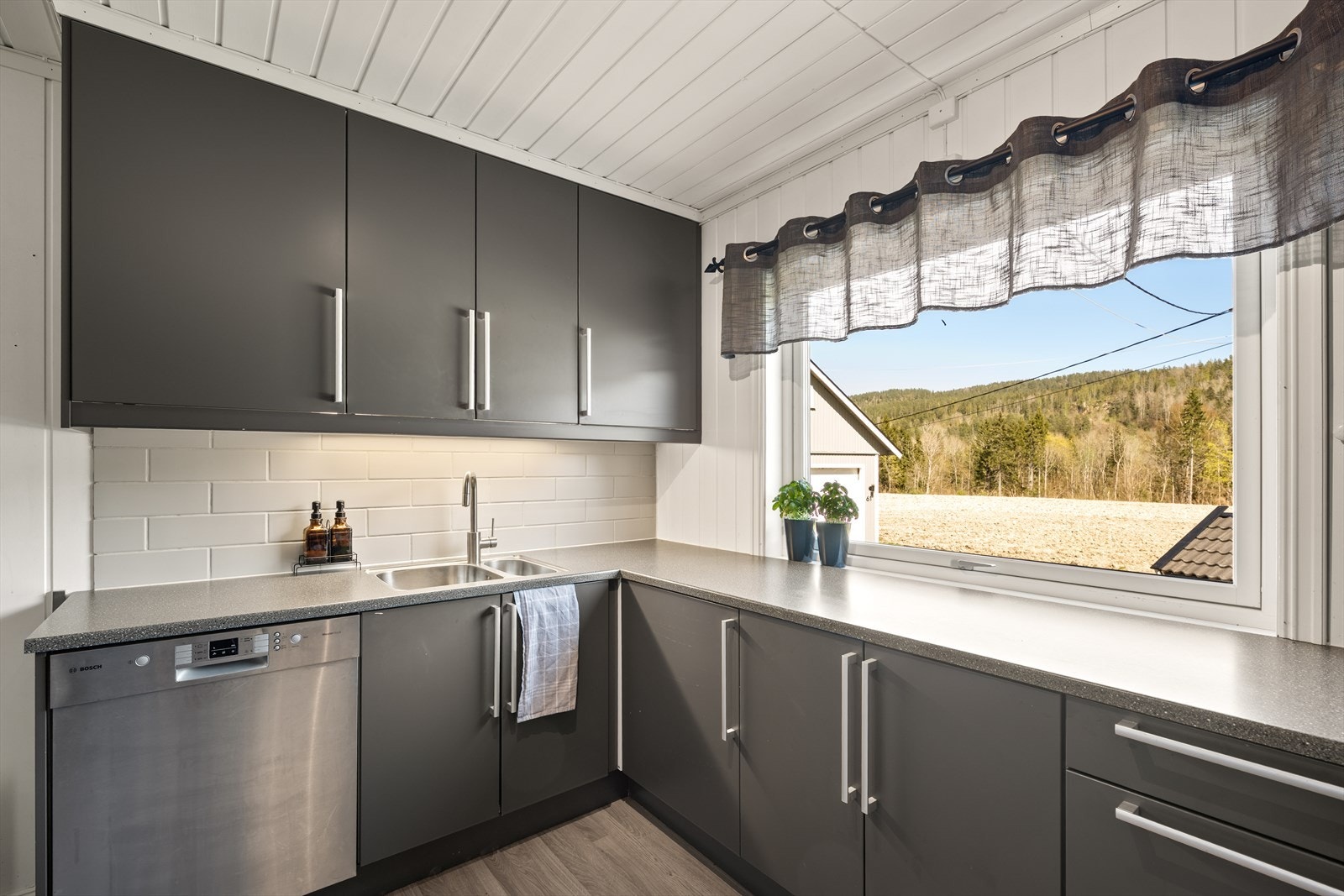 Innredningen har glatte fronter og benkeplate i slitesterk laminat. Kjøkkenventilator har avtrekk ut. Galleribilde