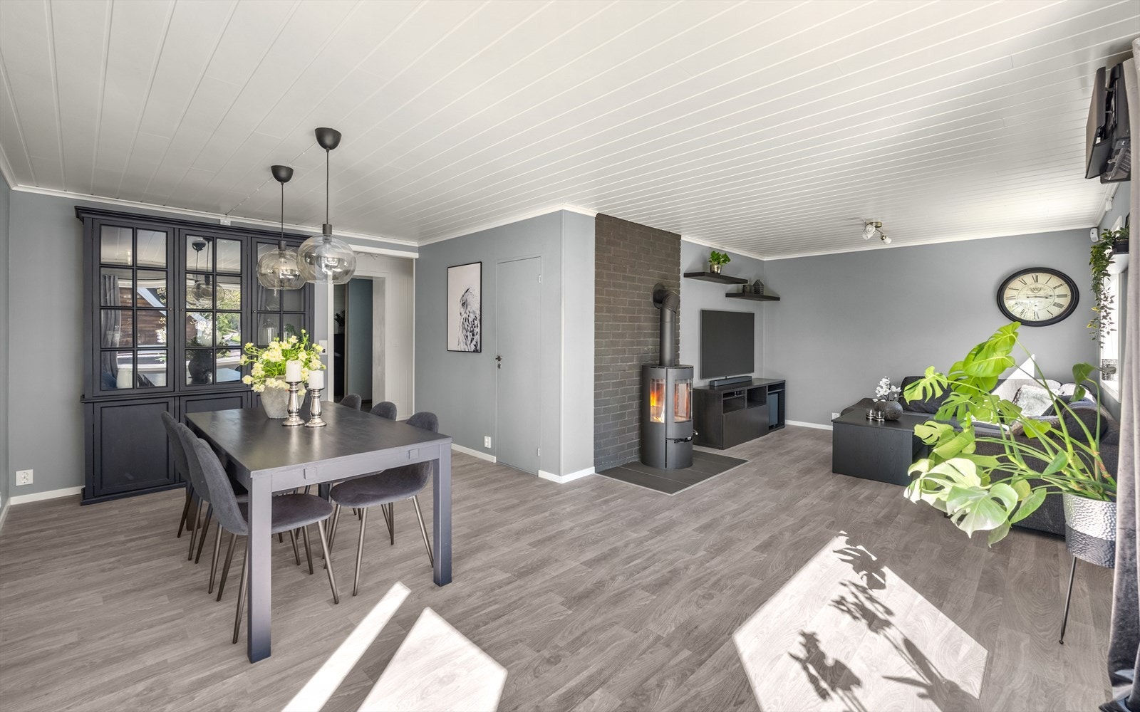 Stuen er romslig med plass til både sofagruppe og spisebord. Peisovnen gir god varme. Galleribilde