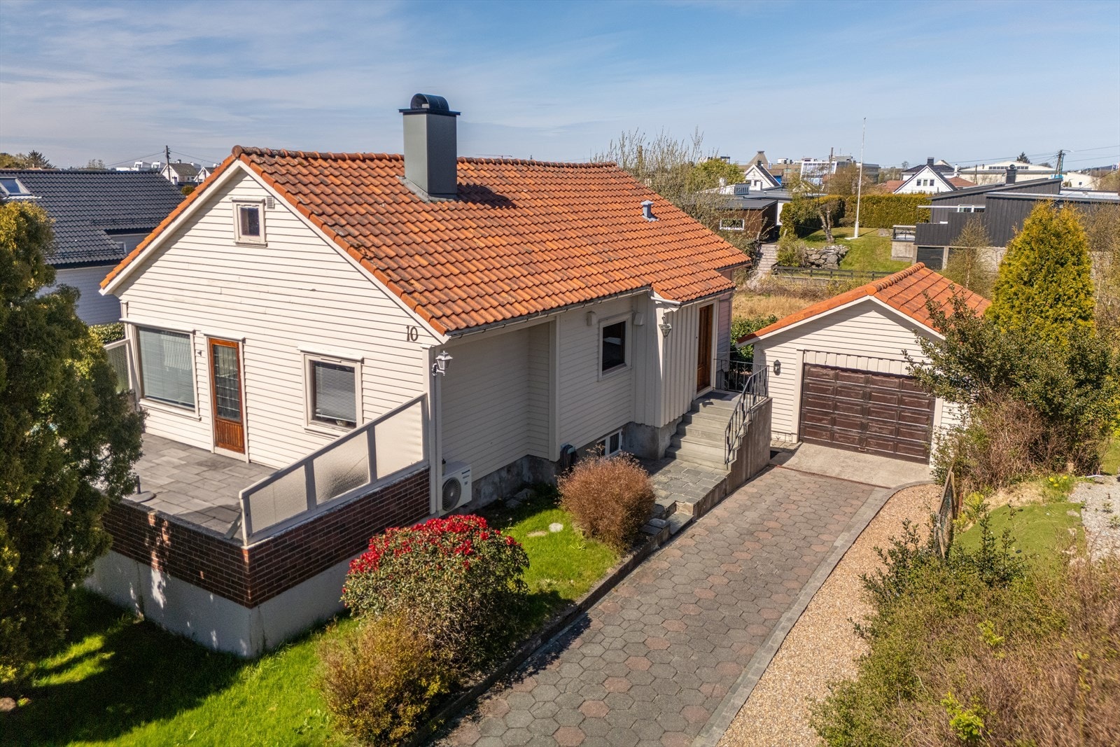 Flott opparbeidet tomt med gårdsrom belagt med beleggingstein og flott opparbeidet hage Galleribilde