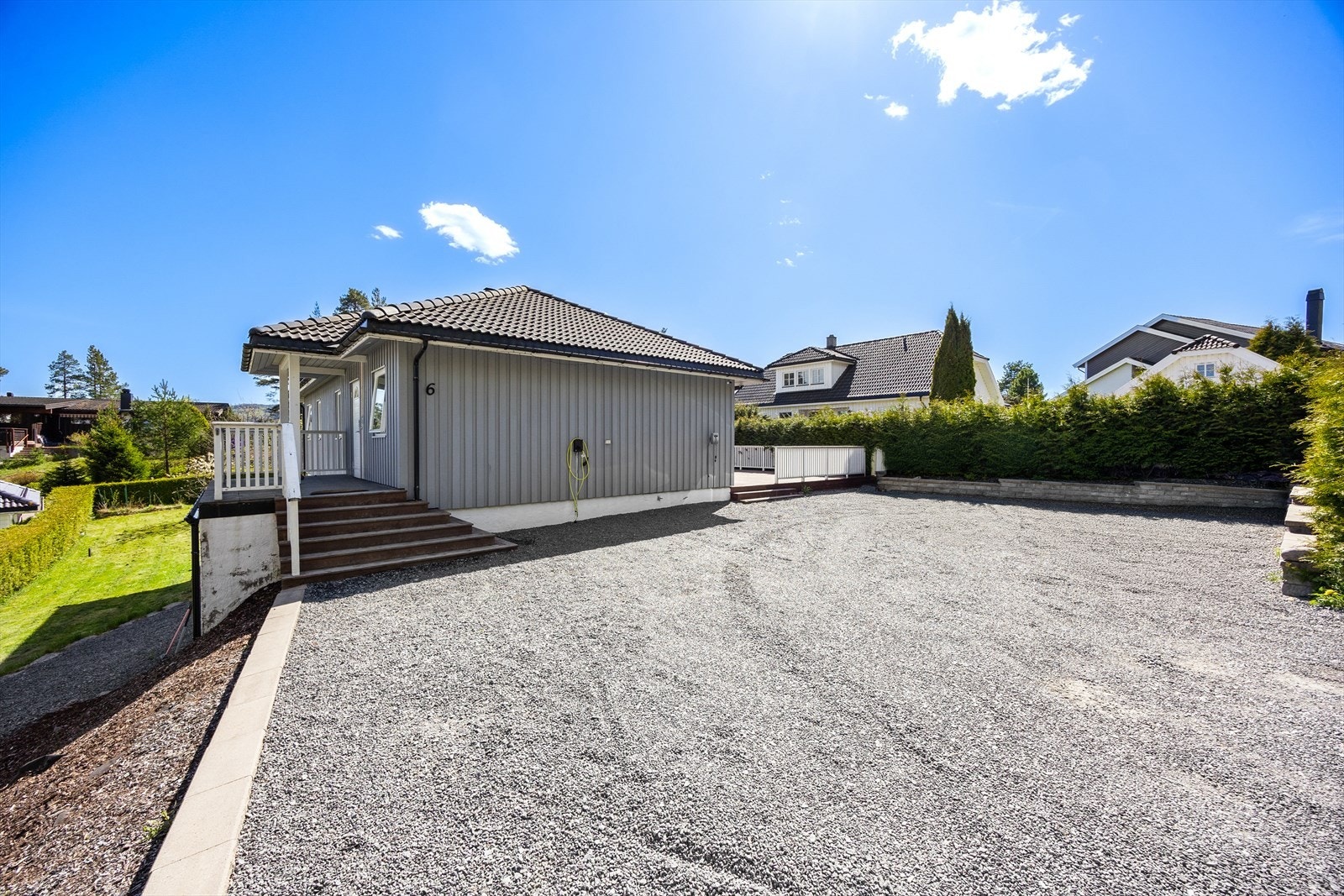 Stor, gruset gårdsplass med rikelig med biloppstillingsplasser. Galleribilde