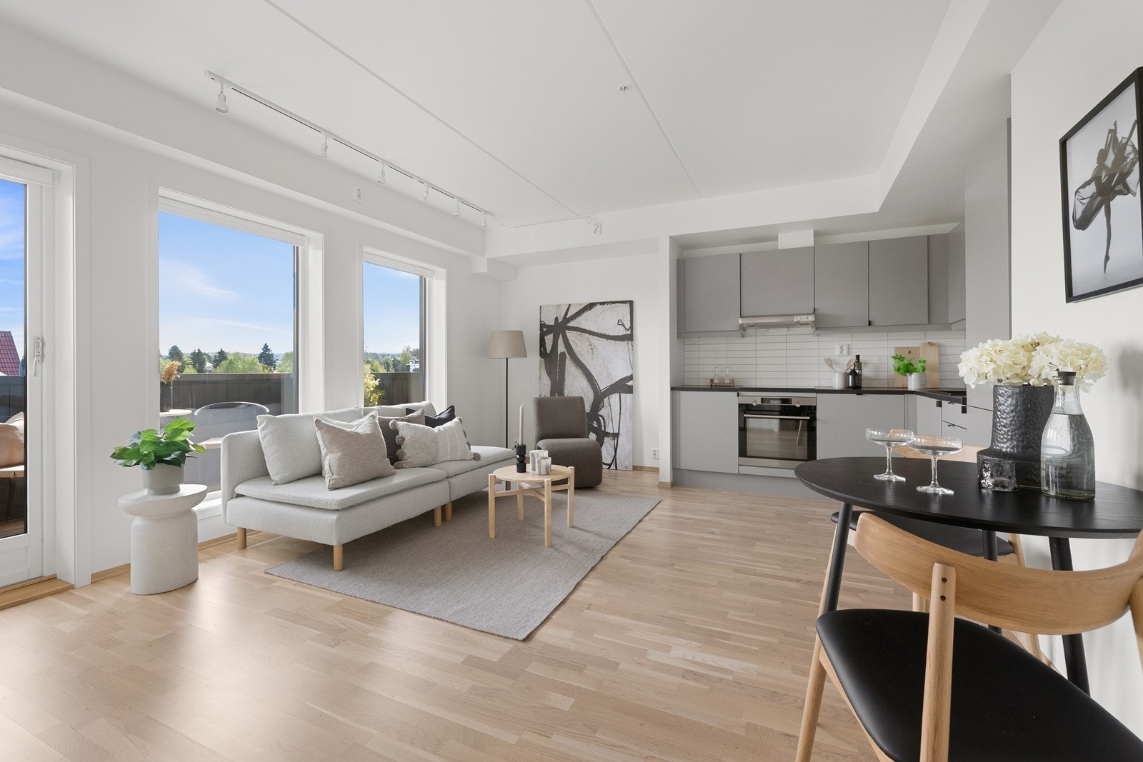 Rommet har en praktisk utforming som gir plass til sofa og lite spisebord. Galleribilde