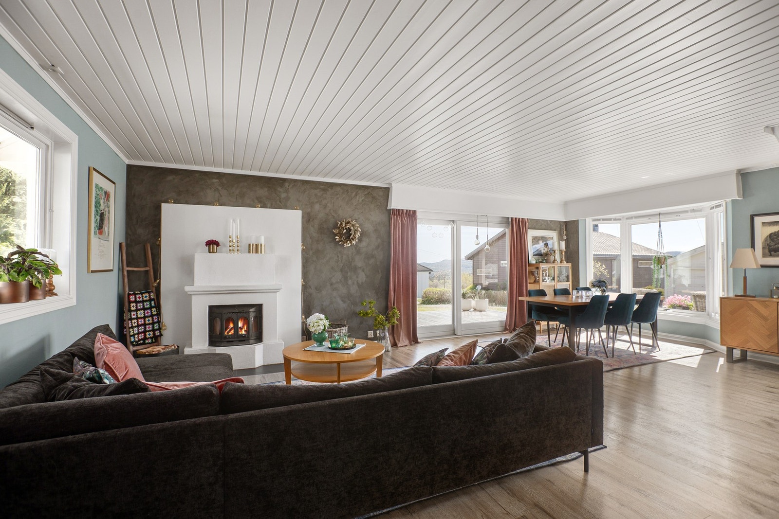 Stuen er utstyrt med hvitmalt elementpeis med innsats, og veggen bak peisen har grå betong-look. Galleribilde