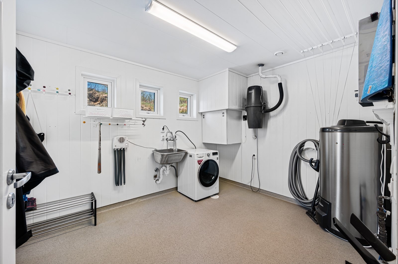 Vaskerommet inneholder utslagsvask, opplegg for vaskemaskin og tørketrommel, ventilasjonsaggregat, varmtvannsbereder, sikringsskap og fordelerskap for rør-i-rør-system. Galleribilde