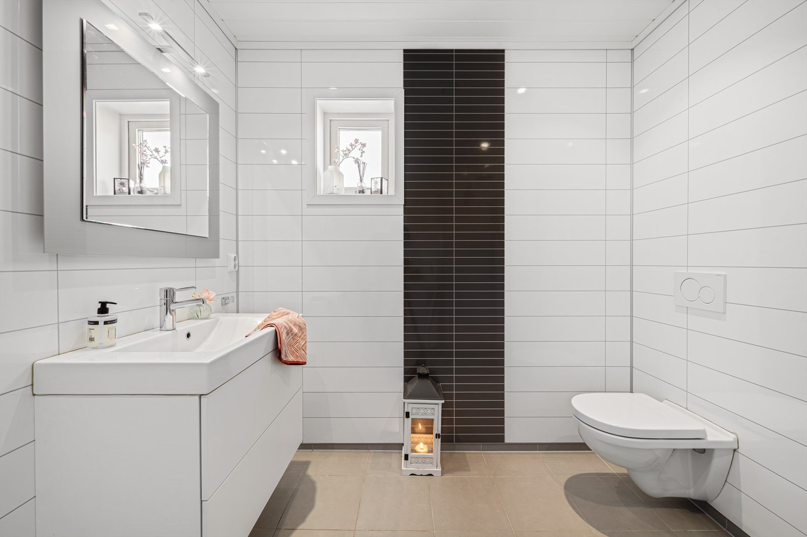 Badet i hovedetasjen har fliser på gulv, baderomsplater på vegger og innfelte spotter i himling. Galleribilde
