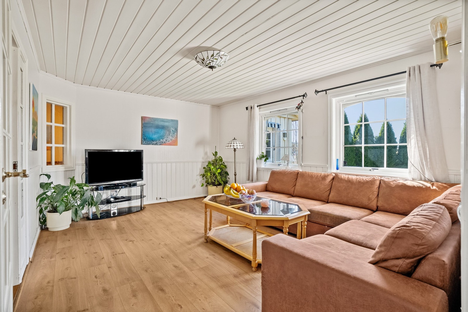 Lys og innbydende stue med god plass til sofagruppe og store vindusflater. Galleribilde