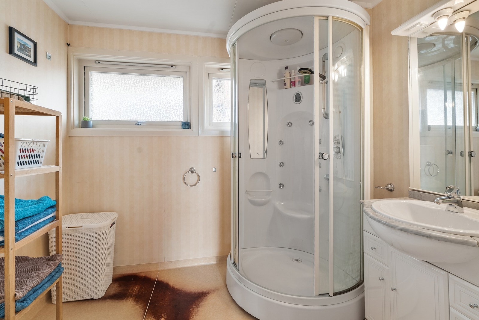 Badet er utstyrt med dusjkabinett, servantinnredning og varmekabler i gulvet. Galleribilde