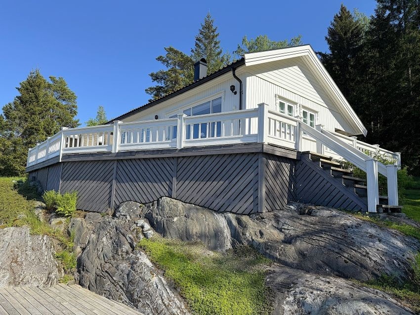 Tomten er fordelt over flere nivåer med plattinger, gress og fjell. Galleribilde
