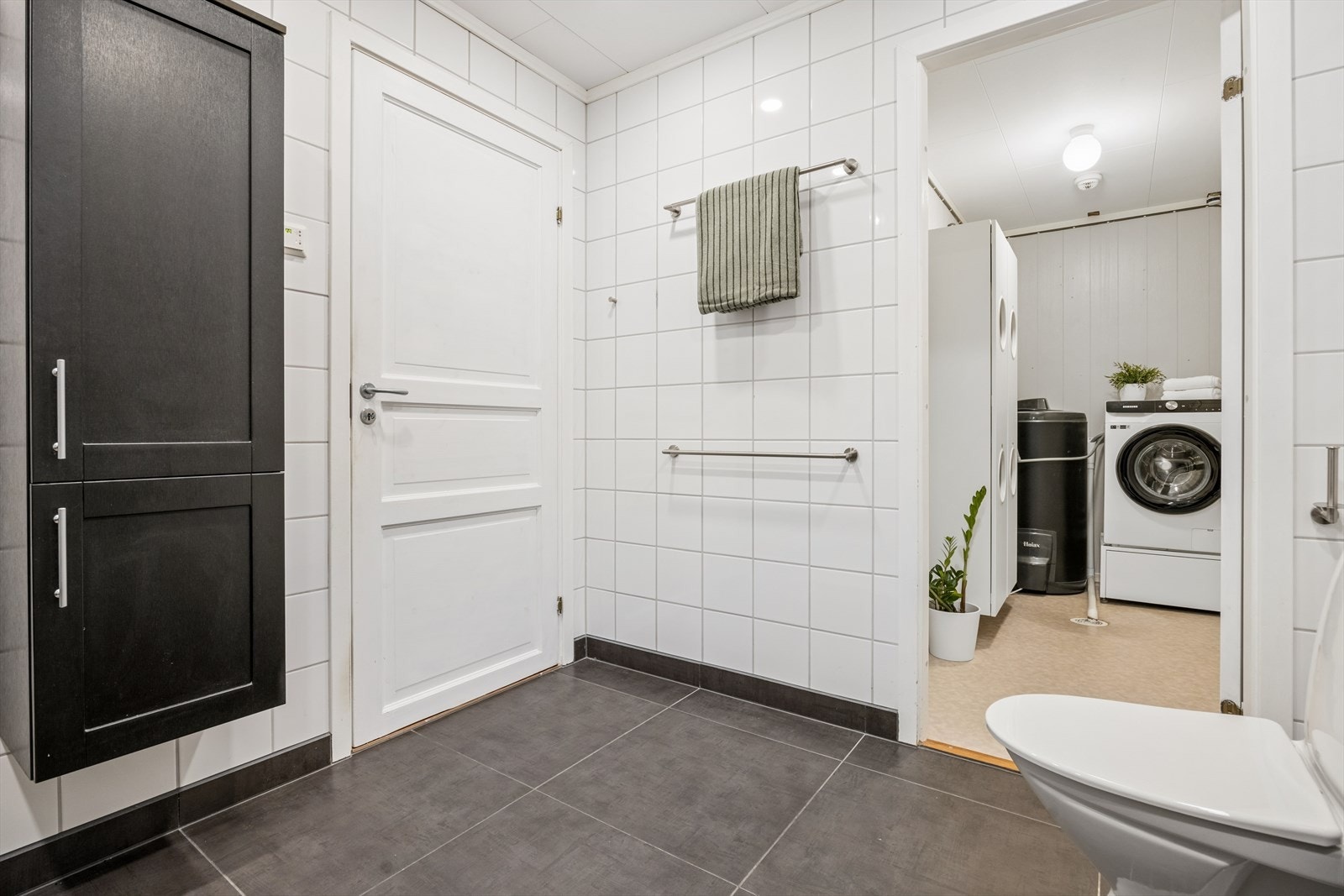 I tillegg er det montert to vegghengte skap som gir ekstra lagringsplass. Badet er utstyrt med gulvstående toalett og dusjløsning med glassvegger og dusjgarnityr på vegg Galleribilde