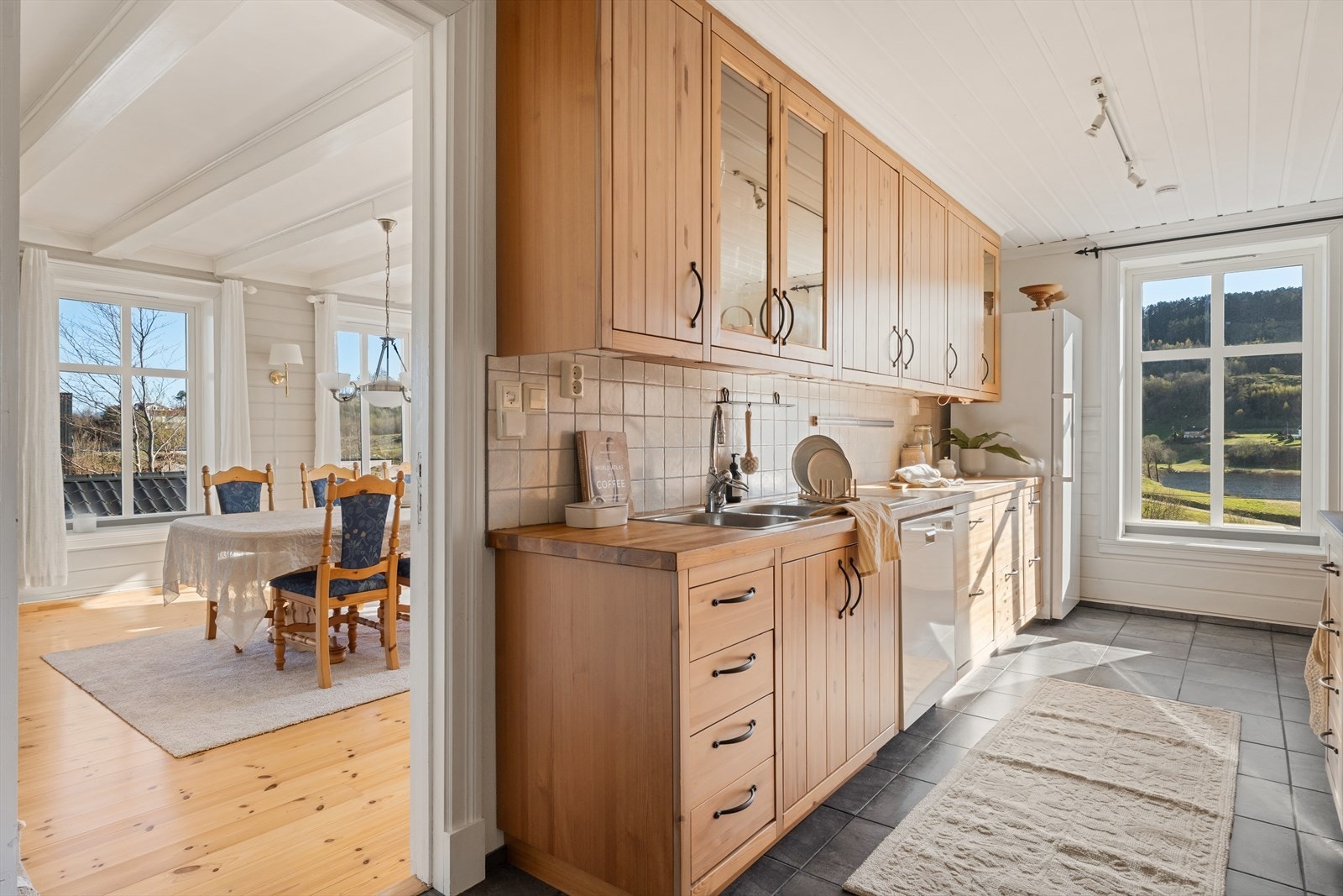 Kjøkkenet er innredet med kjøkkeninnredning i heltre med profilerte fronter i naturlig trefarge, noe som gir rommet et varmt og tidløst uttrykk. Galleribilde