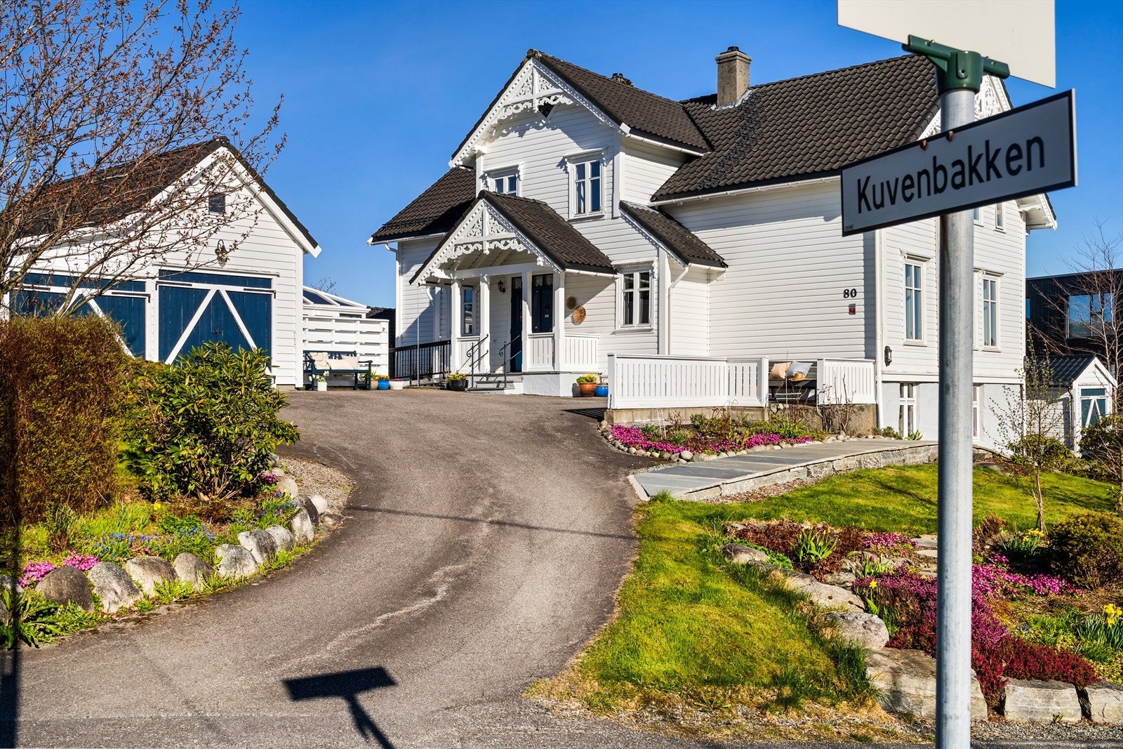 En herskapelig villa i sveitserstil med parkmessig opparbeidet hageanlegg, frittstående dobbelgarasje og flere nydelige uteplasser. Galleribilde