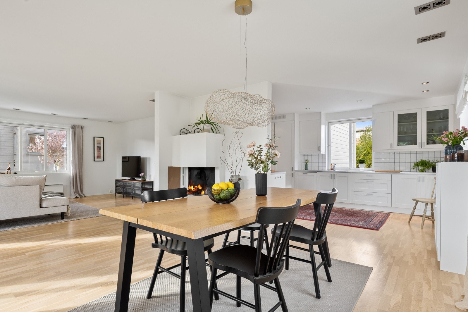 Spisestuen er plassert i åpen løsning mot stuen, med en sentral peis med innsats som et naturlig midtpunkt. Galleribilde