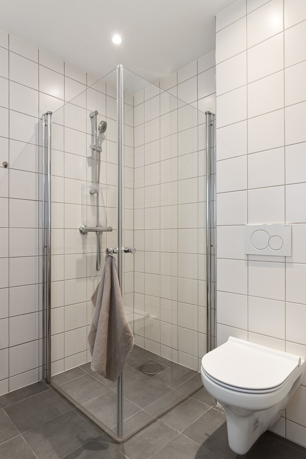 Komfortable varmekabler i gulvet, vegghengt toalett og dusj på gulv med glassdører. Galleribilde