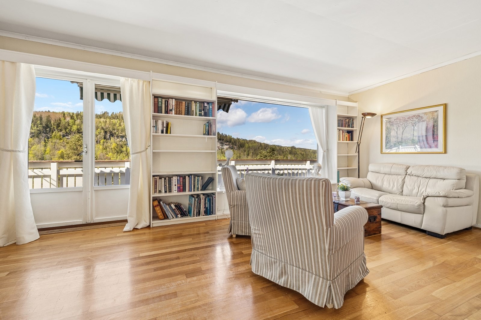 Stuen har god plass til både sofagruppe og lesekrok, med utgang til den store, åpne verandaen. Galleribilde