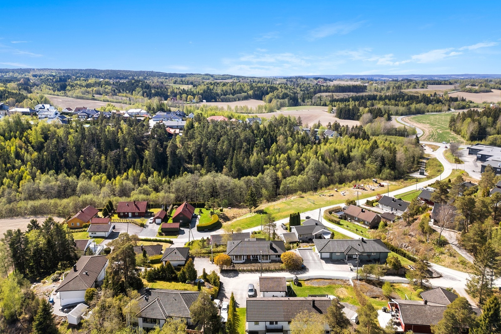 Utsikt over omkringliggende landskap, med åkerland og skogsområder i nærområdet. Galleribilde