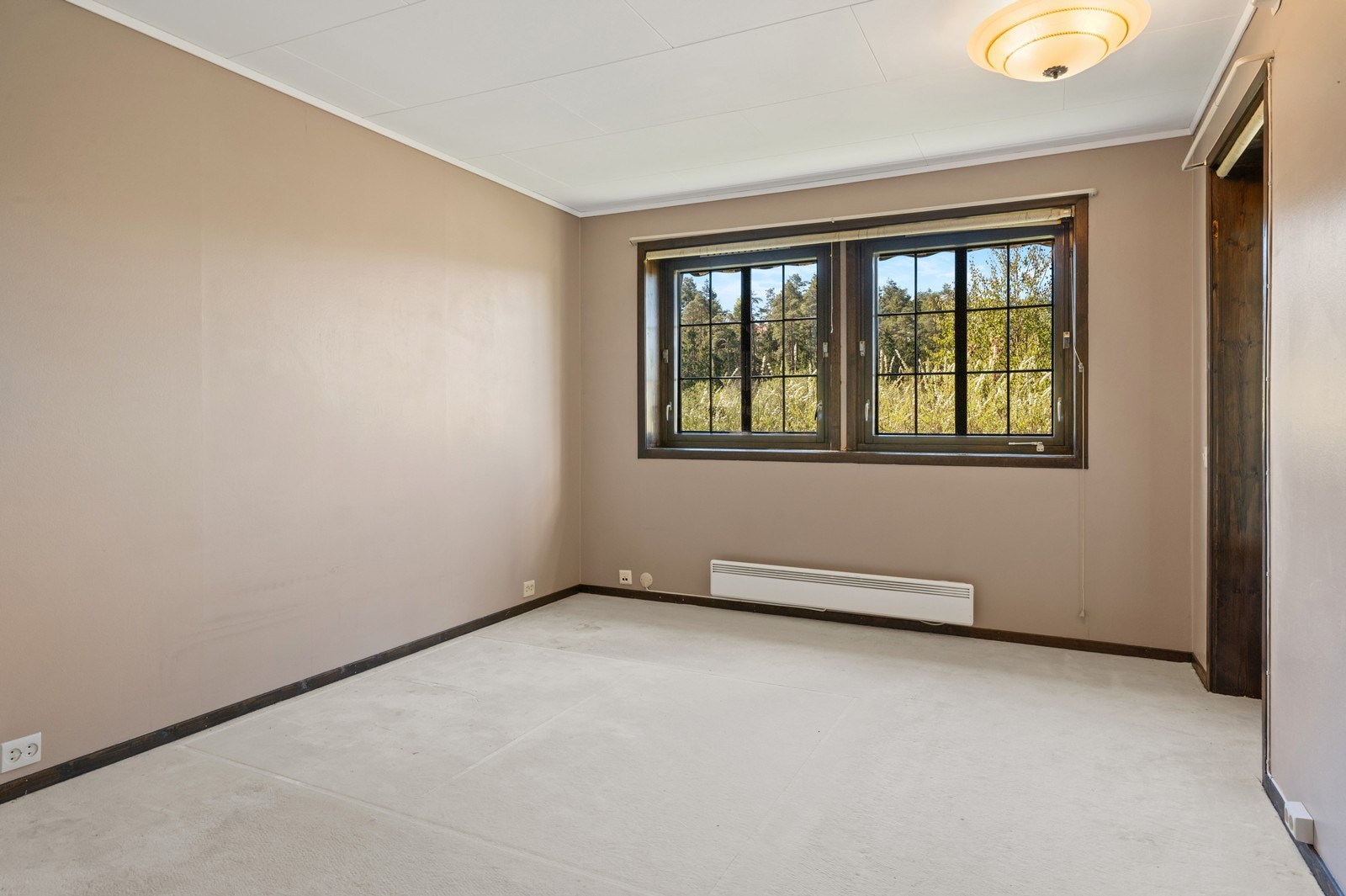 Rommet har teppegulv og store vindusflater som slipper inn naturlig lys. Galleribilde