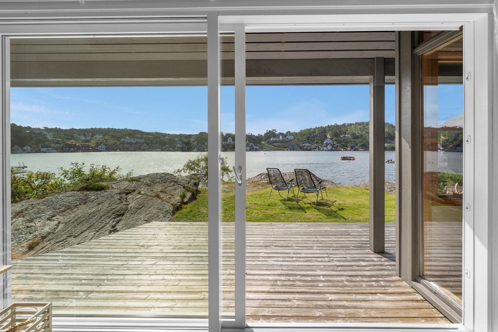 Store skyvdører i glass tar skjærgården inn i stua. Galleribilde