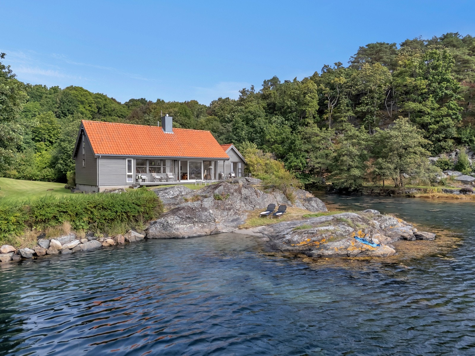 Svaberg og sandstrand bare noen meter fra hytteveggen. Galleribilde
