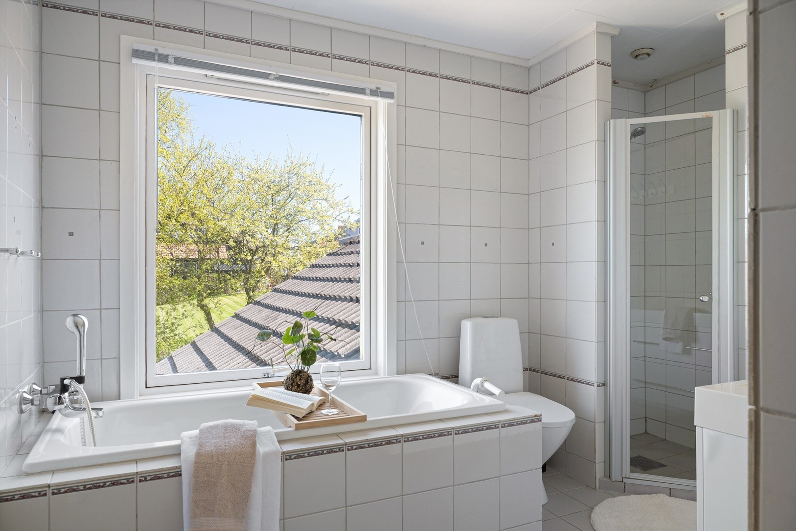 Badet i denne etasjen er helfliset og inneholder dusjhjørne, vegghengt servant med underskuffer, speil med belysning, vegghengt toalett og badekar. Galleribilde