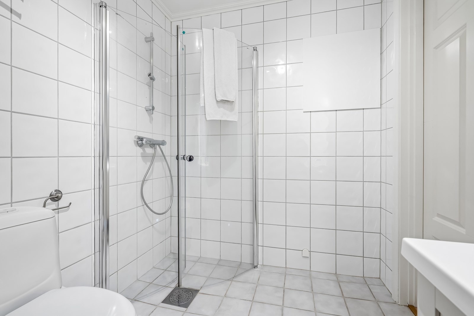 Badet er bla. utstyrt med innfellbare dusjdører, gulvvarme og opplegg for vaskemaskin Galleribilde