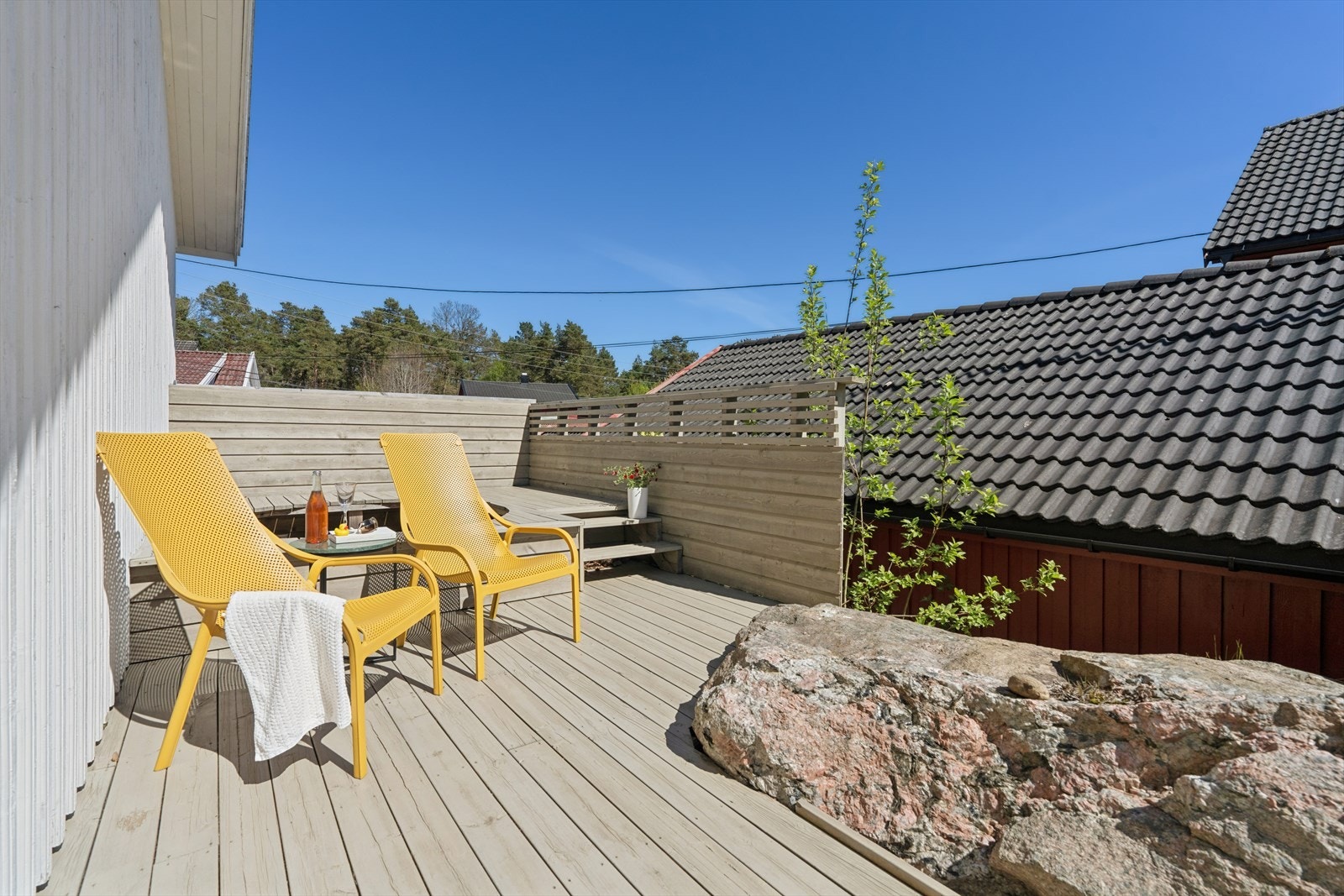 Terrasse som strekker seg langs østsiden av boligen, med deilig morgen- og formiddagssol. Mulighet for etablering av jacuzzi bak stolene i bildet. Galleribilde