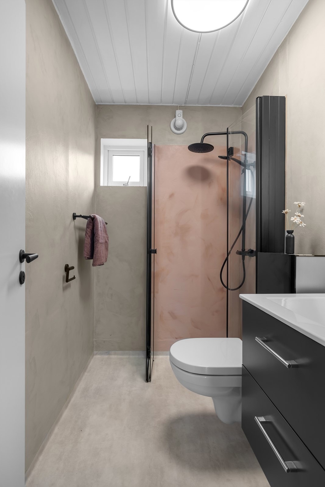 Dusj/toalettrommet byr på moderne og praktiske innredninger som bla. vegghengt toalett og lekker regndusj med armatur i svart utførelse. Galleribilde