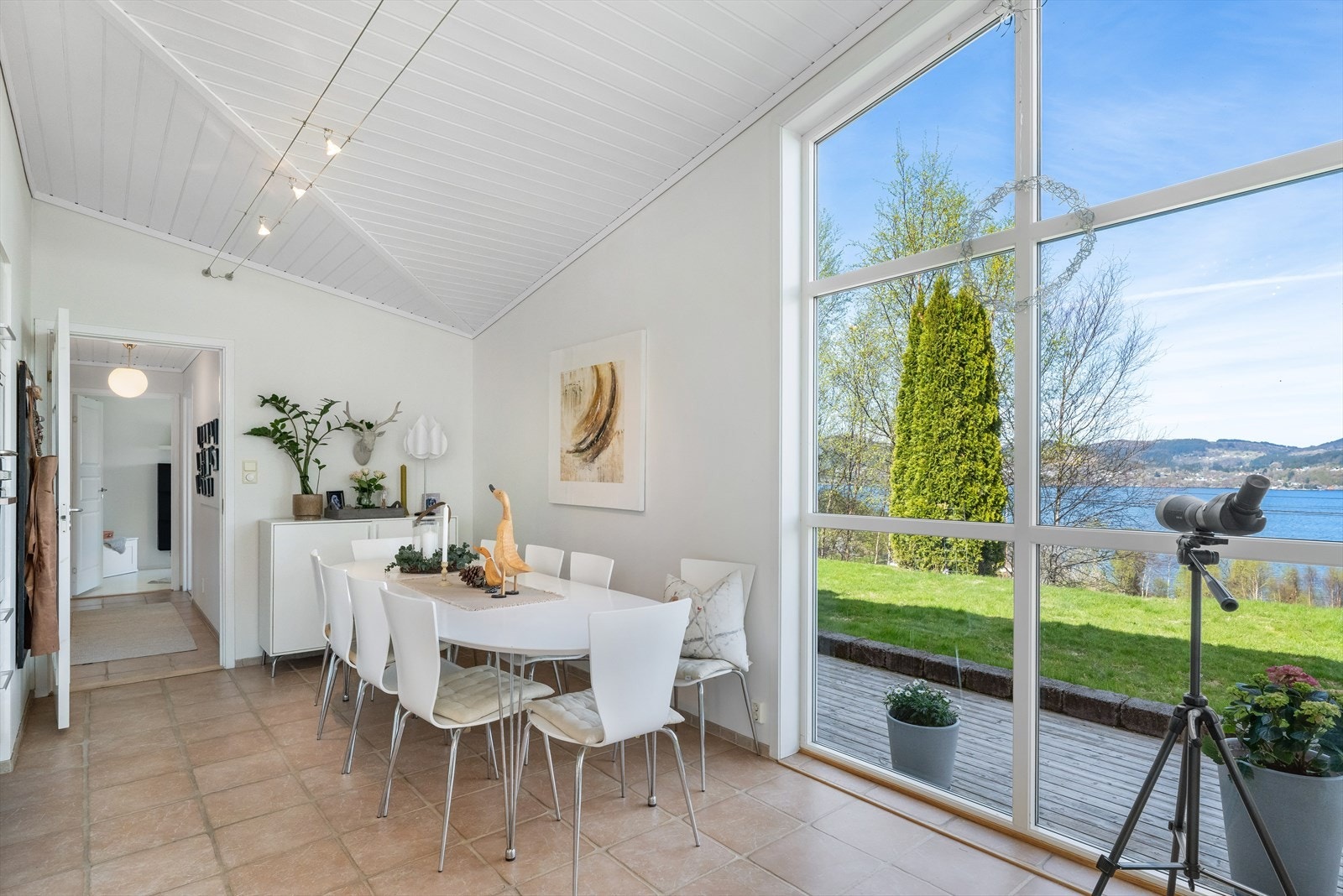 Spisestuen er plassert ved et stort vindusparti som rammer inn utsikten mot hagen og sjøen. Galleribilde