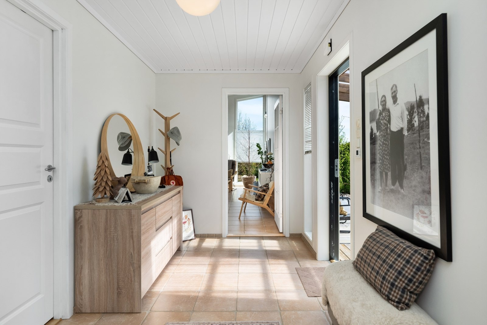Fra et overbygget og skjermet inngangsparti kommer man inn i en romslig gang med flislagt gulv. Galleribilde