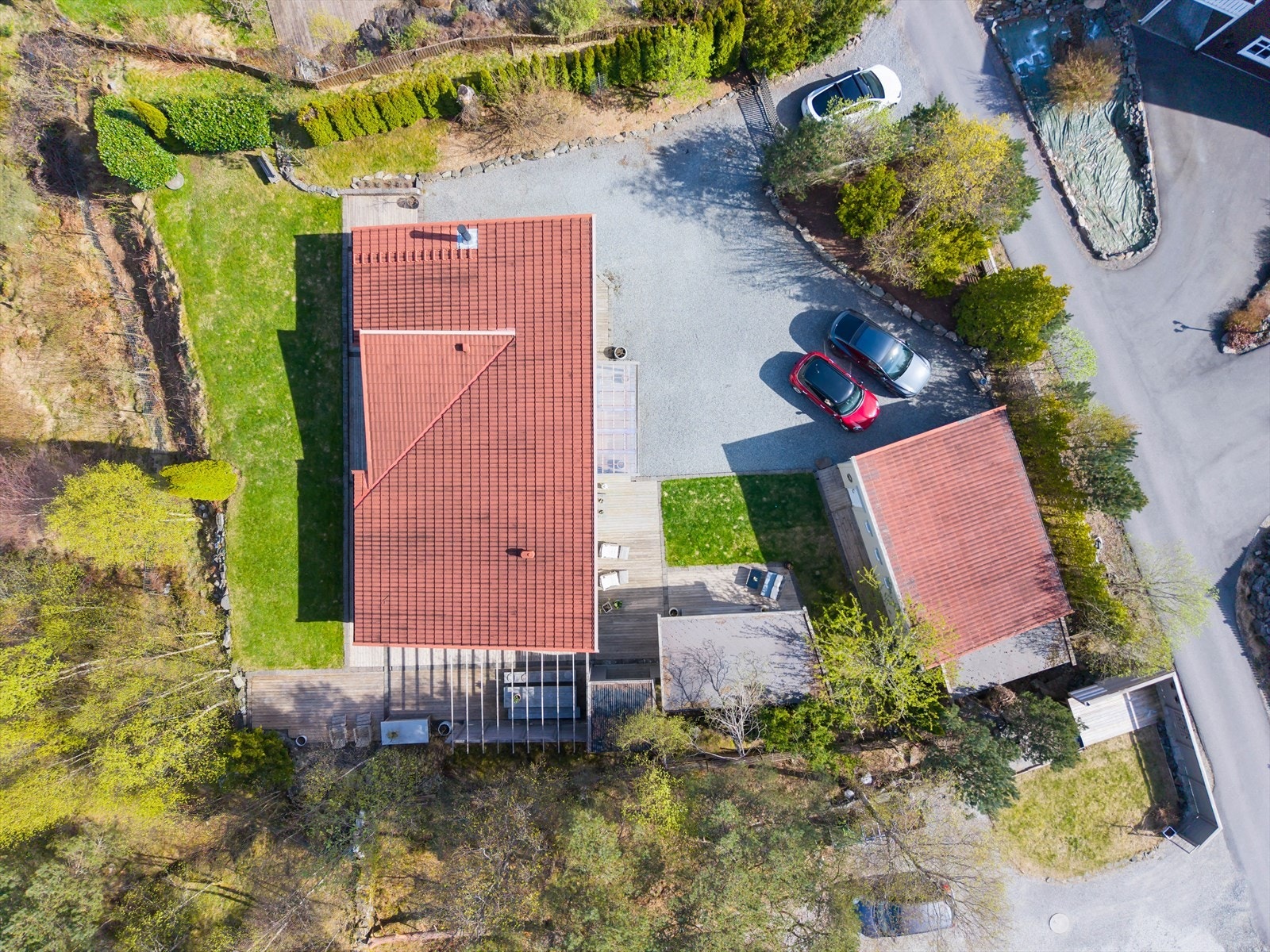 Eiendommen sett fra luften, som viser boligens plassering på tomten sammen med garasje og utestue. Galleribilde