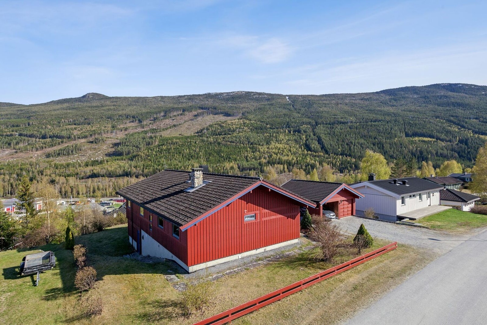 Gruset adkomst og parkering i tillegg til plen, hekk og diverse beplantning. Galleribilde