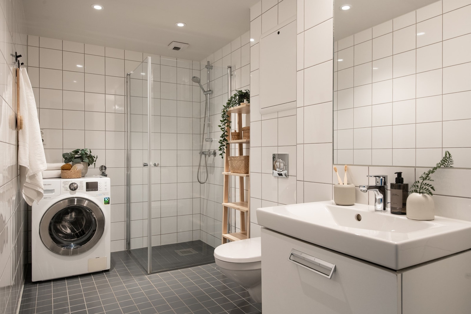 Delikat og flislagt bad med gulvvarme og himling med downlights. Vegghengt speil med belysning og stikkkontakt. Galleribilde