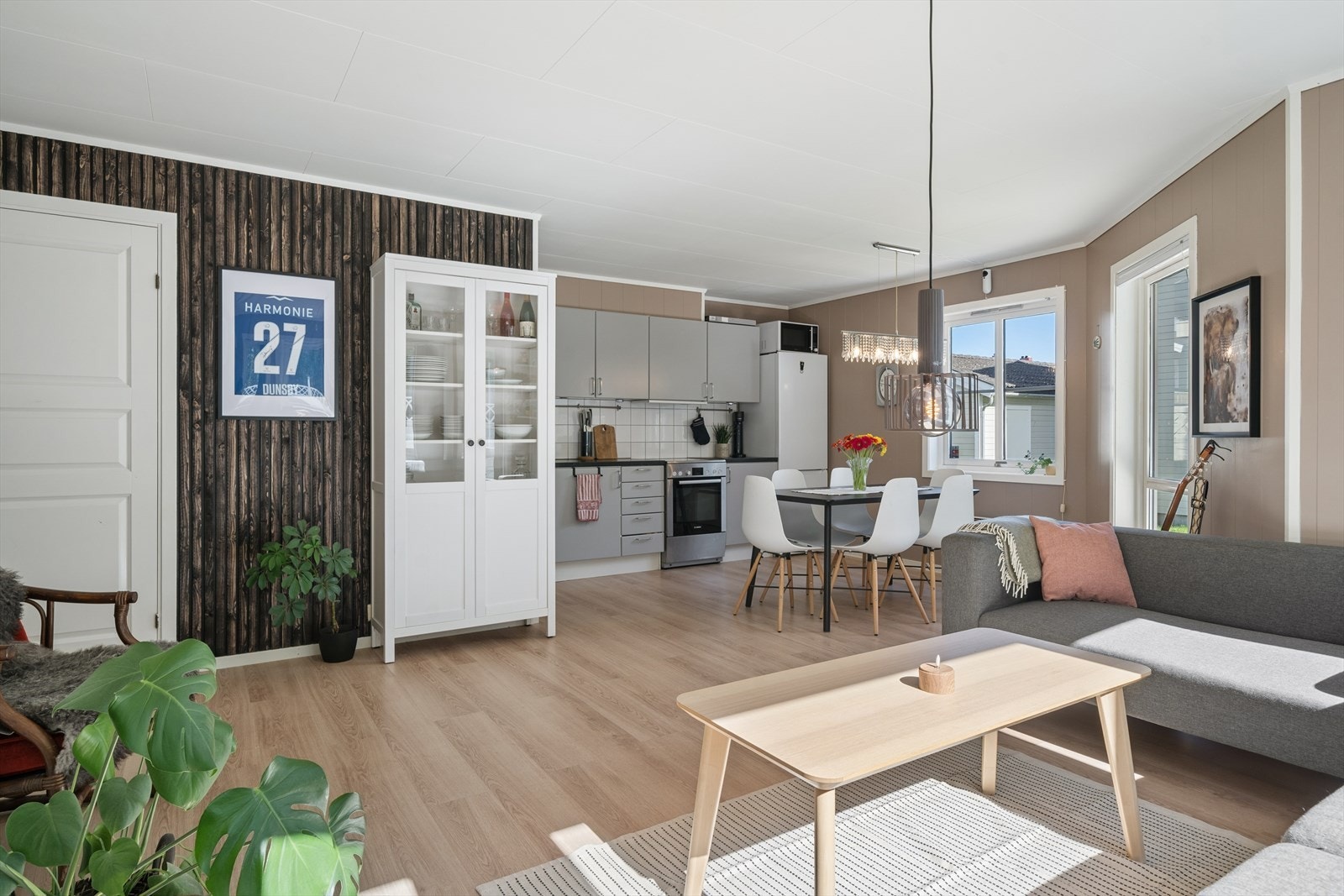 Gjennomgående gulv og harmoniske fargevalg skaper et helhetlig og innbydende uttrykk som egner seg godt for både hverdag og sosiale sammenkomster. Praktisk innvendig bod rett frem og utgang til terrasse til høyre. Galleribilde