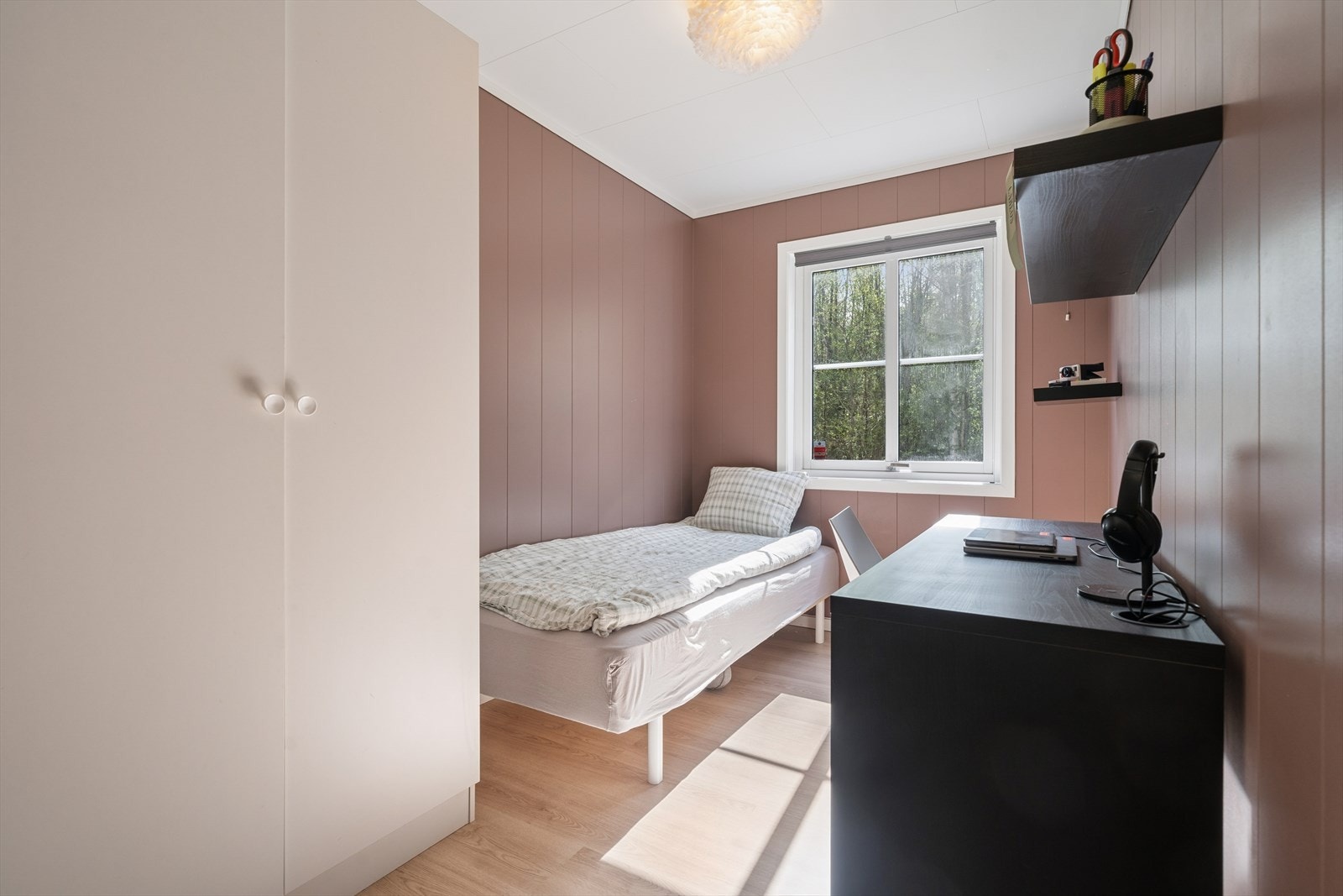 Lyst og trivelig rom som egner seg godt som soverom, barnerom eller hjemmekontor. Rommet har vindu som gir godt naturlig lysinnfall og utsyn mot grønne omgivelser. Galleribilde