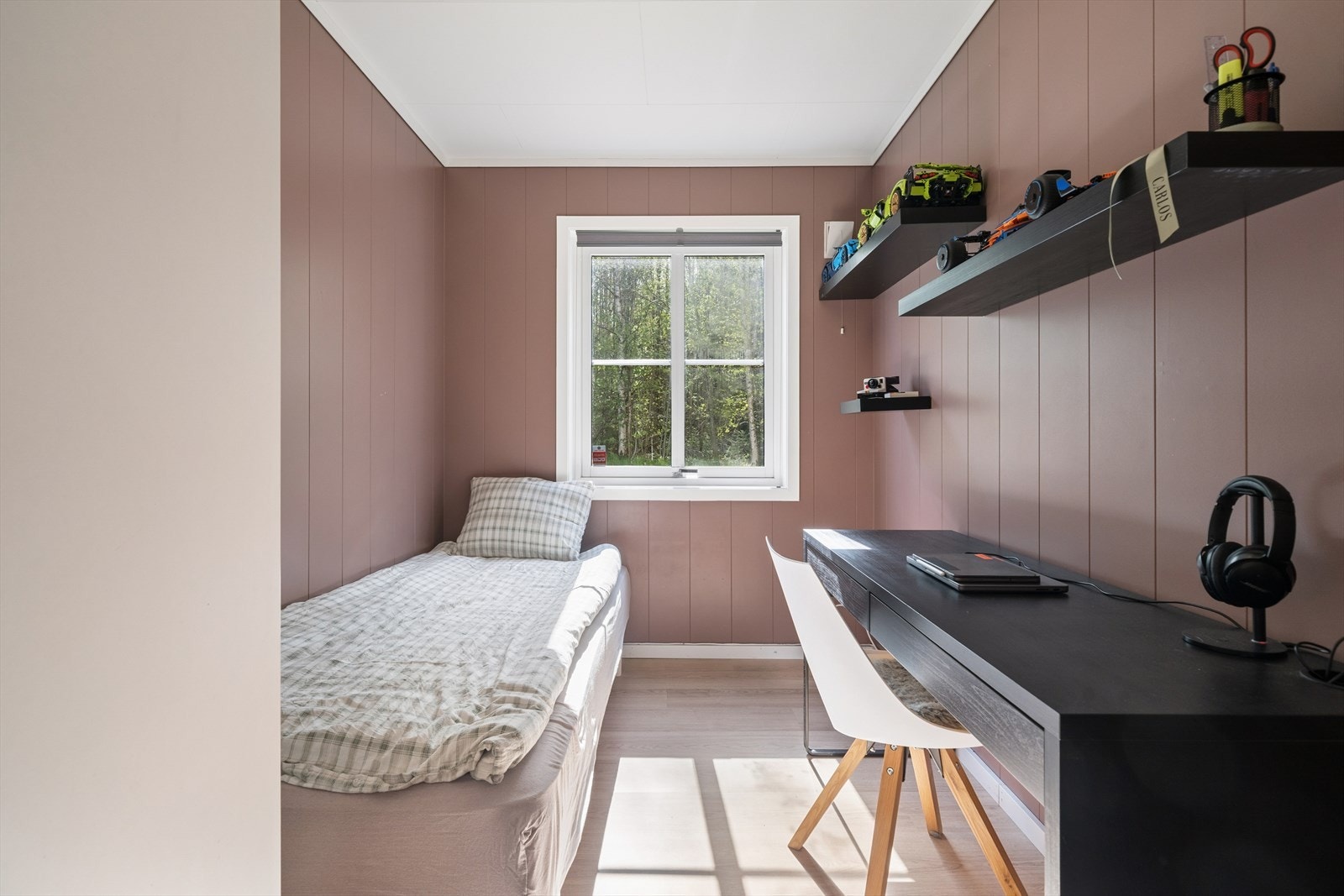 Soverom ll har plass til både seng og skrivebord, med praktiske hyller som gir god oppbevaringsmulighet. Rolige fargetoner på veggene og gjennomgående gulv skaper en behagelig og lun atmosfære. Galleribilde