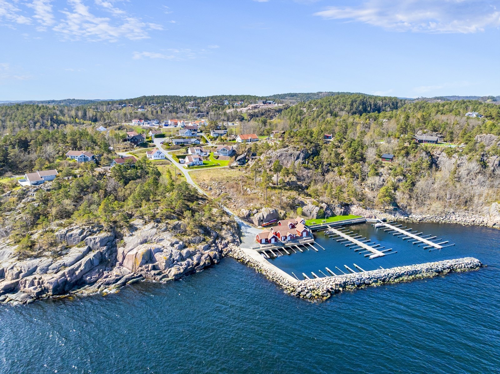 Naturskjønne og sjønære omgivelser med tilhørende bryggeplass og sjøbod i lun båthavn med molo. Galleribilde