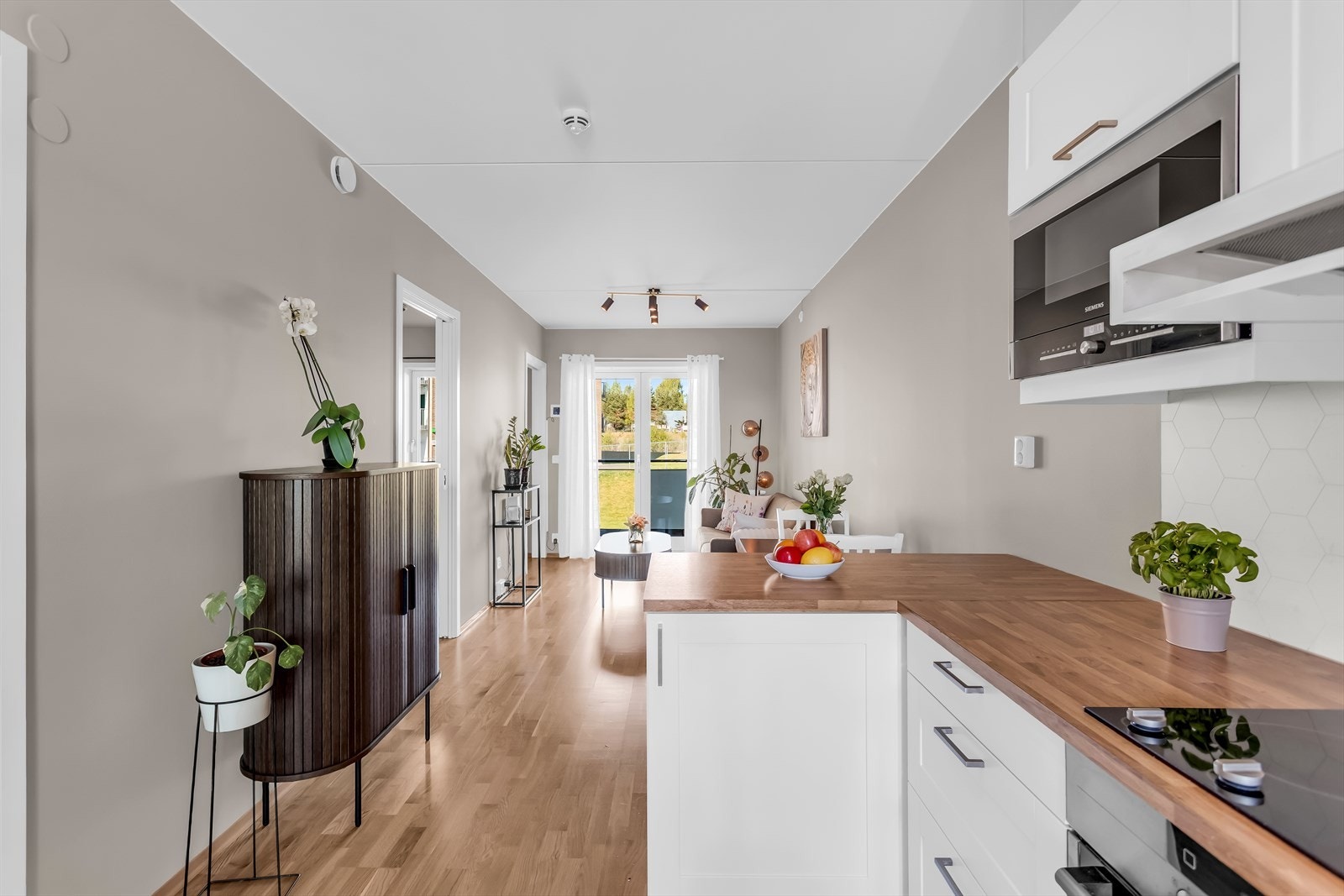 Gjennomgående laminatgulv i alle oppholdsrom skaper en helhetlig stil. Galleribilde