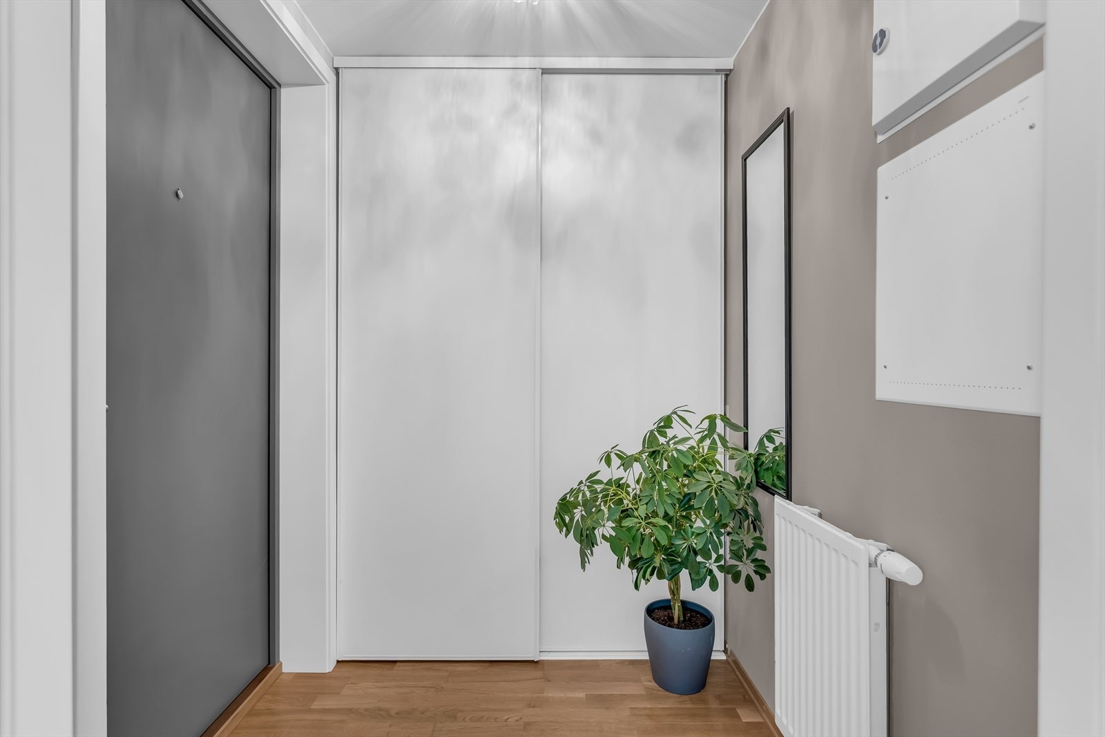 Entré med plass til yttertøy i skyvedørsgarderobe. Leiligheten har balansert ventilasjon og oppvarming via radiatorer. Galleribilde