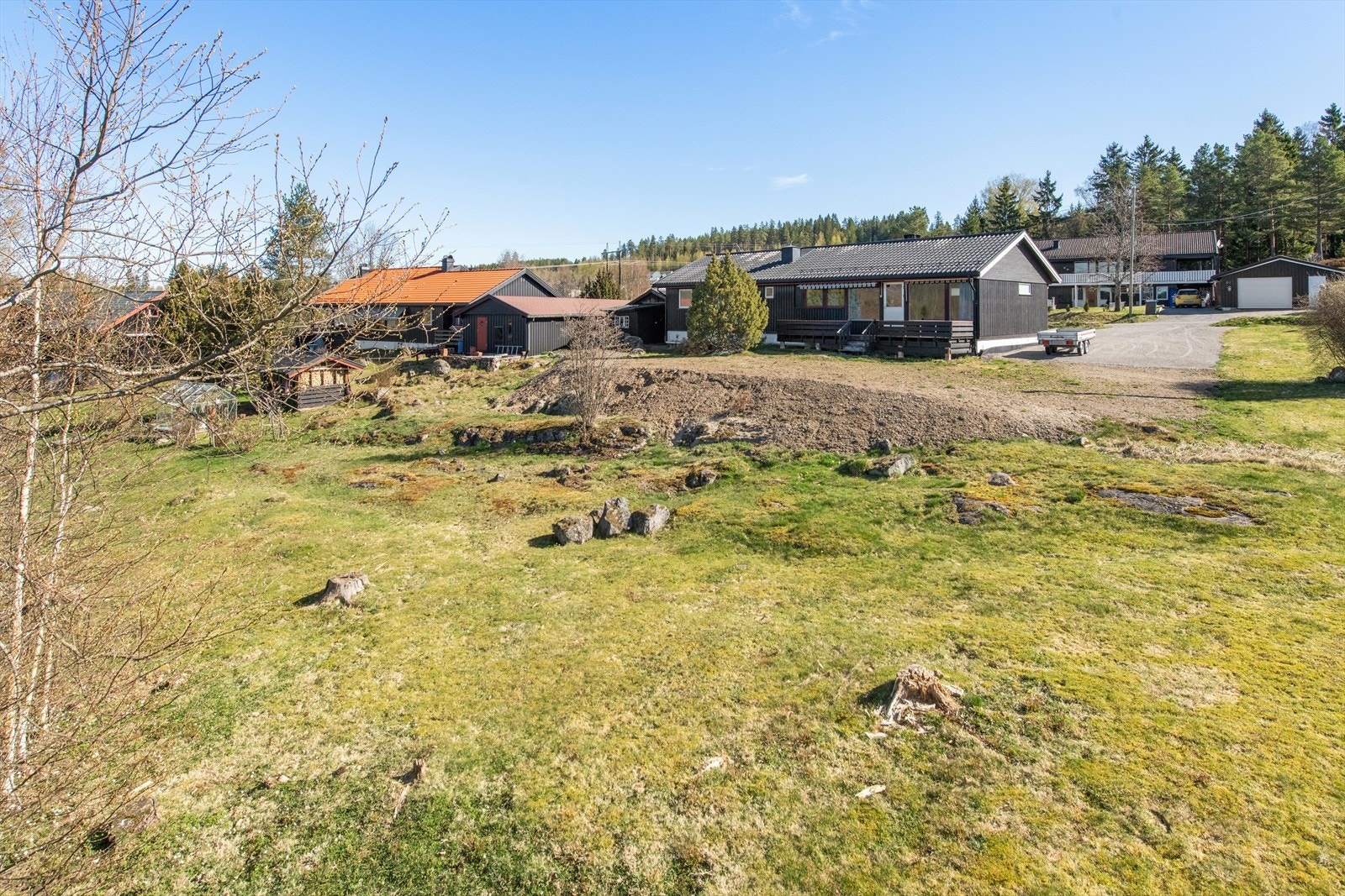 Tomten er planert rundt boligen og ellers kupert. Galleribilde