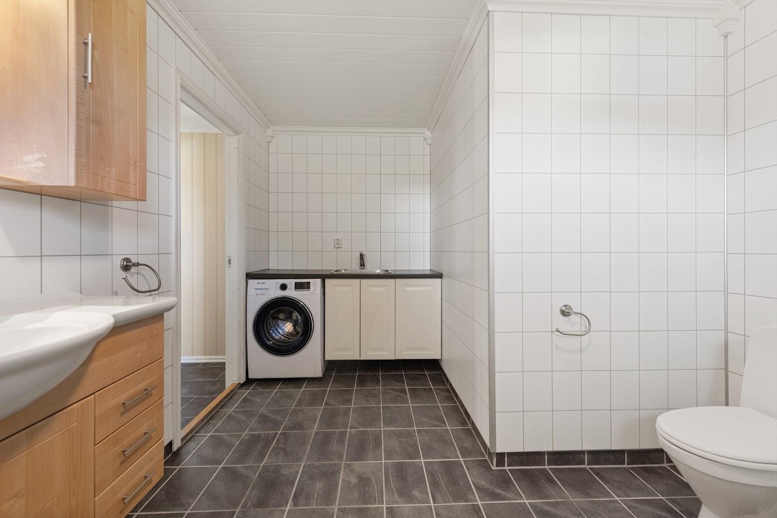 Egen nisje med vaskeromsinnredning og opplegg for vaskemaskin. Galleribilde