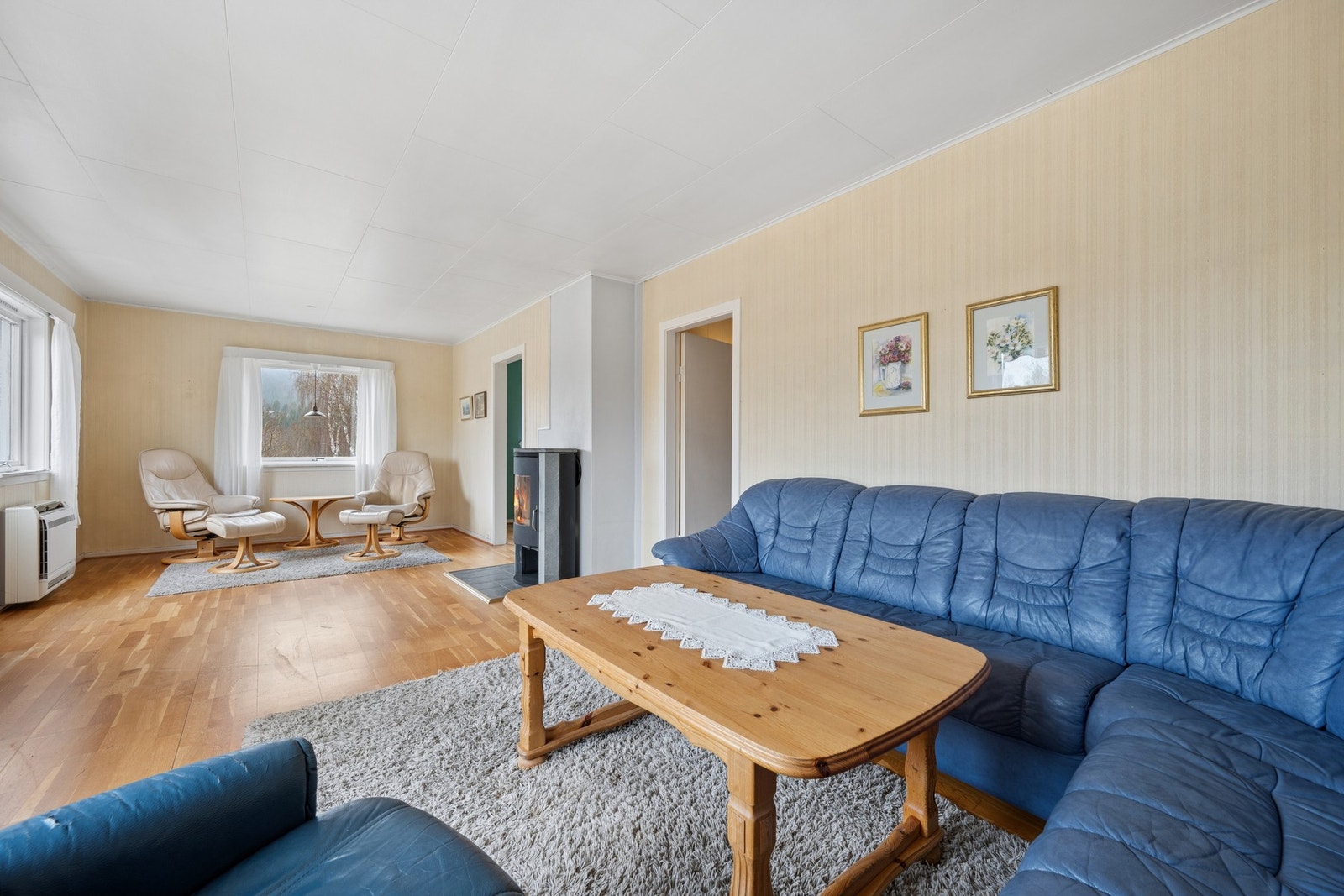 Romslig stue med plass til flere sittegrupper. Galleribilde