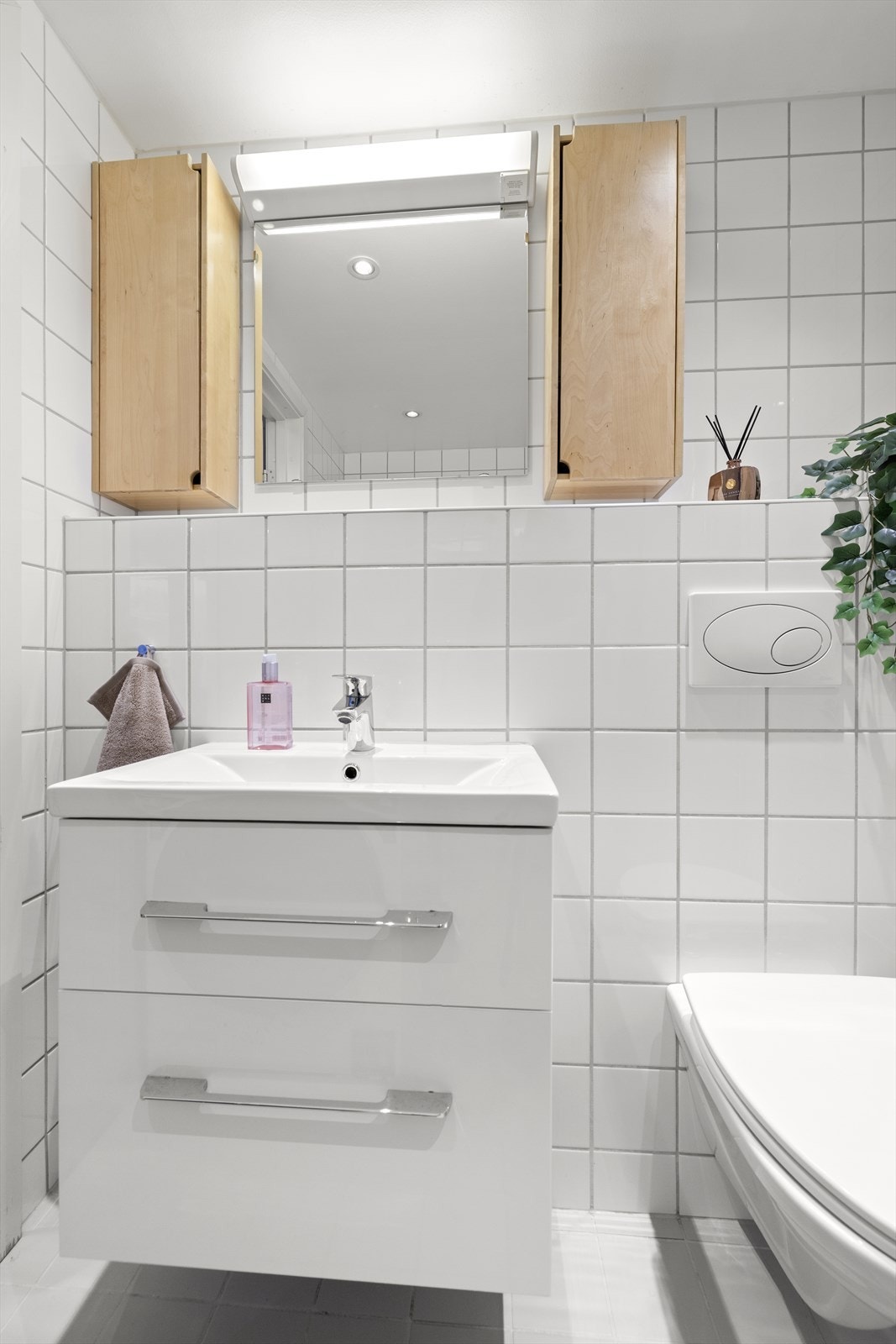 Badet er utstyrt med vegghengt toalett med innebygget sisterne, servantinnredning og downlights i taket. Galleribilde