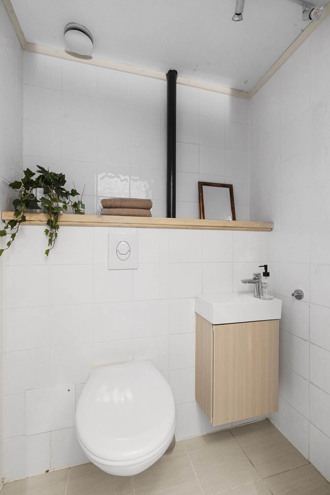 Praktisk og stilrent toalettrom med flislagte vegger og gulv- perfekt ved besøk av gjester. Galleribilde